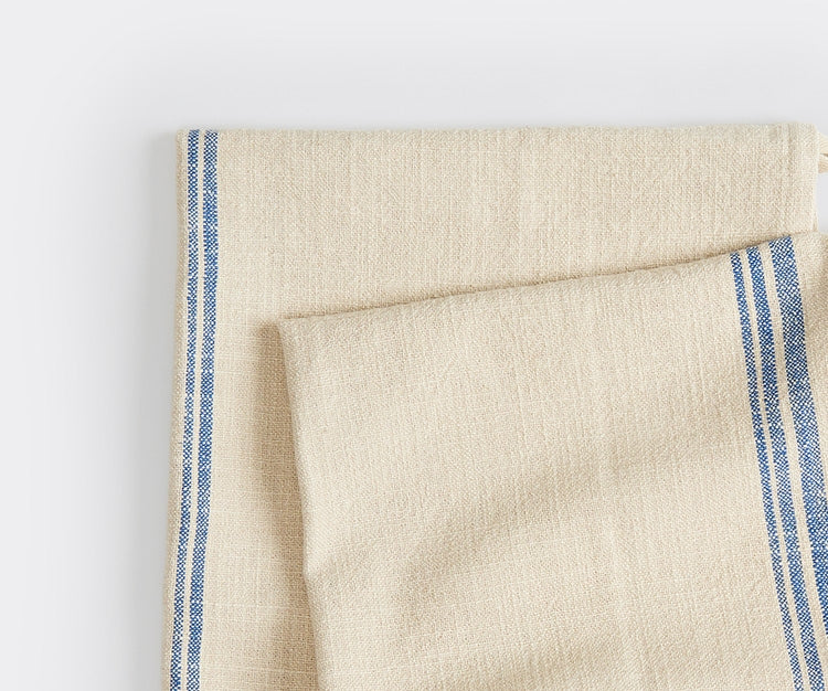 A close-up shot of two folded Misen Kitchen Towels on top of each other and slightly fanned out. The texture and design on the towels are clearly visible.