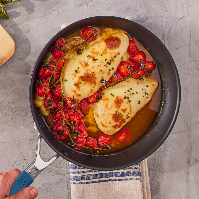 Picking up an Original Misen Nonstick Pan with mozzarella chicken and tomatoes