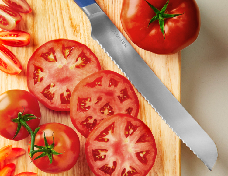 Slicing beef steak tomatoes with a blue, eight inch Misen Serrated Knife