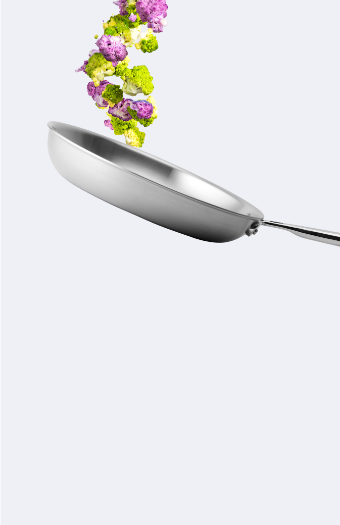 Flipping broccoli and purple cauliflower in a Misen stainless steel skillet