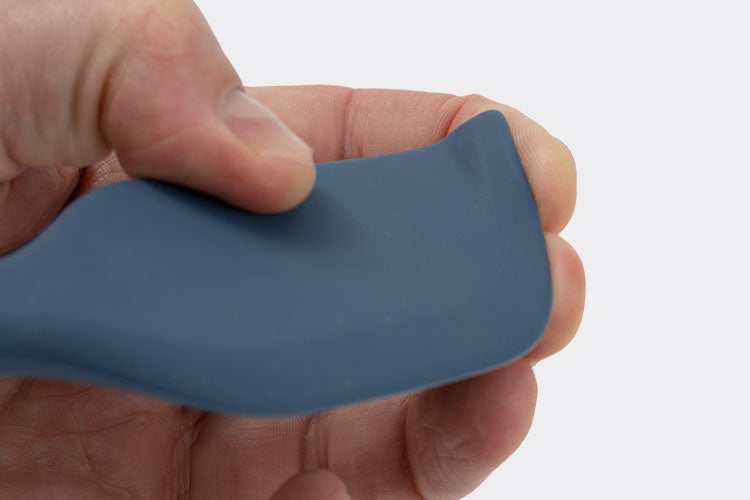 A close view of a hand bending the tip of a Blue Misen Mixing Spatula’s head against its fingers.