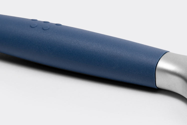 Close view of a Blue Misen Peeler’s silicone handle, with raised Misen logo and base of the metal head visible.
