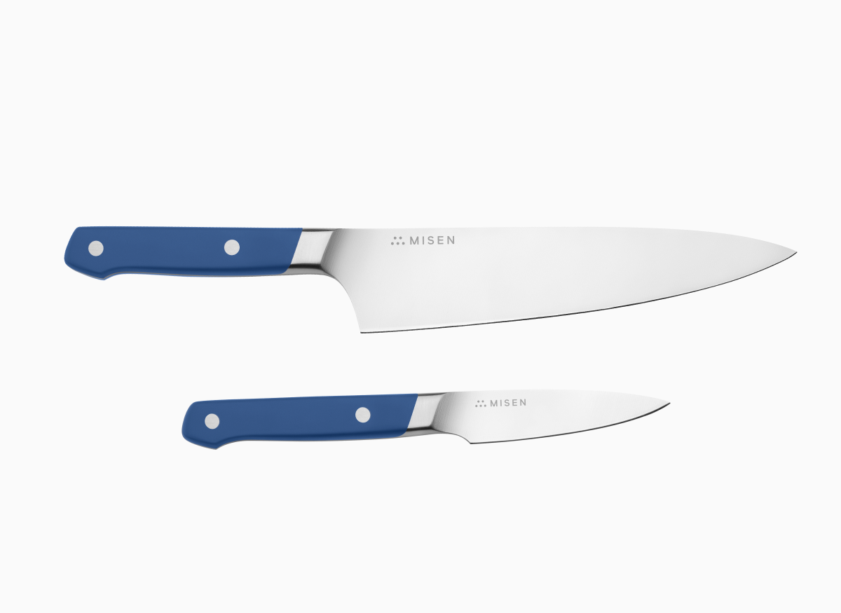 A set of two kitchen knives with blue handles and silver blades, one Chef's, one Paring, laid on a white surface.
