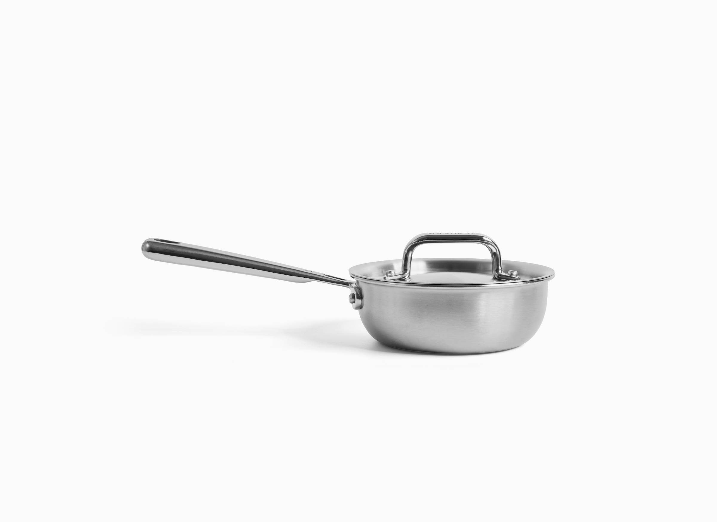 A polished Misen stainless steel saucier, with a long handle and a fitted lid, is depicted against a white background. The saucier appears to be about .75 quart in size.