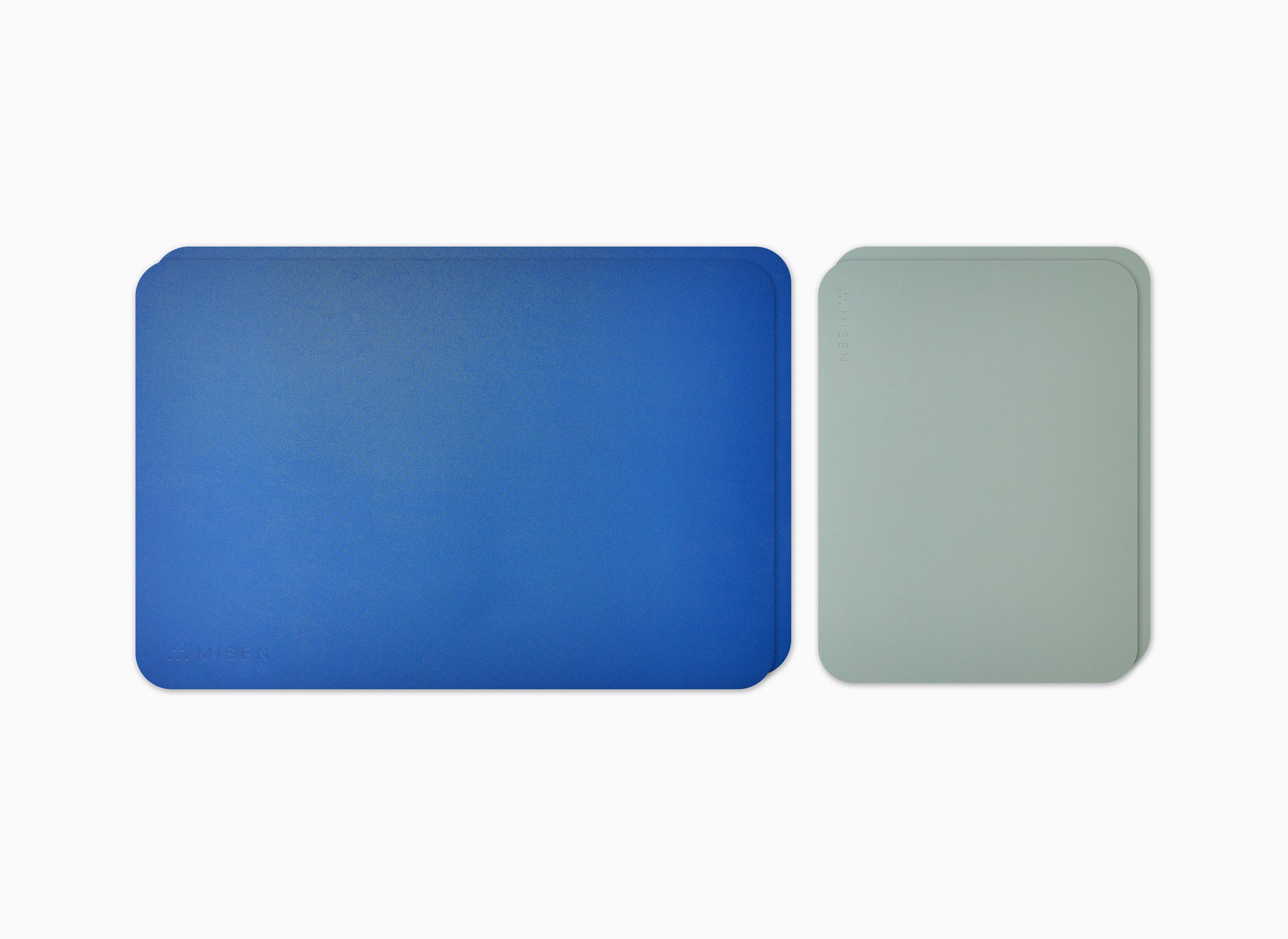 Two small grey Misen Cutting Sheets and two large blue Misen Cutting Sheets seen from directly overhead.